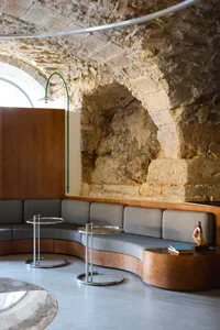 Cozy living space with a sofa, chairs, and dining tables, featuring a warm and inviting atmosphere