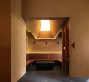 Modern room with orange walls, brown benches, and natural light from a large window