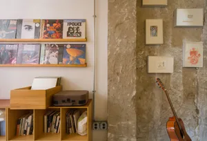 Cozy living area with a bookshelf, electric guitar, and inviting atmosphere