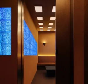Empty modern room with brown walls, a large blue-tinted window, and two doors on either side
