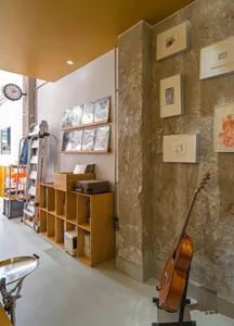 A cozy room with a guitar on the wall, books scattered around, and a chair in the corner, creating a relaxing atmosphere for music enthusiasts