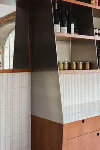 A kitchen area with a countertop featuring various items on display, including bottles and jars of different sizes, creating a well-stocked and ready-to-use atmosphere