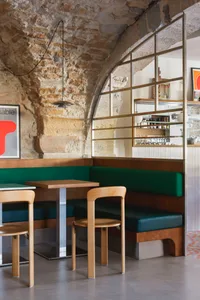 A modern restaurant interior with three wooden tables and chairs, creating a cozy atmosphere for patrons