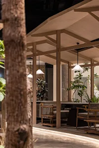 Warm and inviting dining area with wooden tables and chairs, surrounded by potted plants