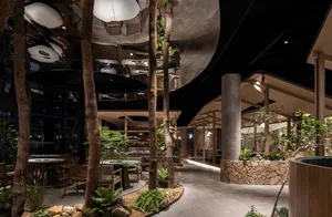 A dimly lit restaurant interior with dining tables, chairs, potted plants, and trees, featuring modern and stylish design elements, including wood and glass materials