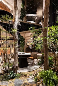 A cozy restaurant seating area with chairs, a dining table, and potted plants, creating a warm and inviting atmosphere