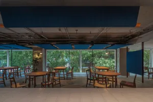A well-lit dining area with a large wooden table and multiple chairs, surrounded by inviting decor