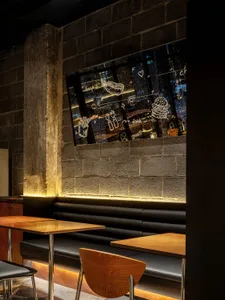 A restaurant interior with multiple dining tables, chairs, and a couch, creating a warm and inviting atmosphere