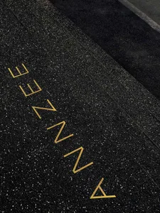 A modern sign with black and gold lettering on a black background, possibly a floor plan or architectural design