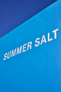 A blue wall with white lettering that reads Summer Salt, creating a clean and modern look with contrast and visual interest