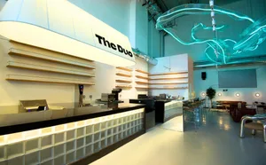 Modern restaurant interior with a bar area, dining chairs, and a focus on functionality and aesthetics