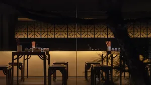 Warm and inviting restaurant interior with wooden tables and chairs, multiple dining tables with chairs, and a cozy atmosphere