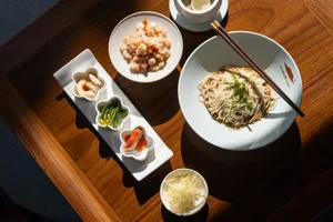 A dining table set with various food items, utensils, and cups, creating a warm and inviting atmosphere in a casual dining environment