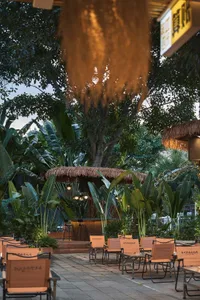 A patio area with wicker chairs arranged around a dining table, set up for socializing and enjoying meals outdoors