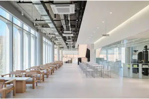 Empty office space with large windows, tables, and chairs, creating a clean and inviting atmosphere