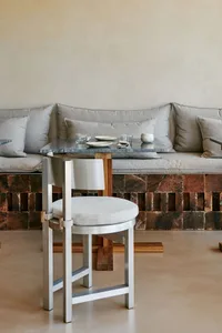 Cozy living area with a couch, chairs, dining table, and marble countertop, featuring a warm and inviting atmosphere