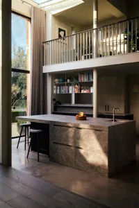 Modern kitchen and dining space with a large island countertop, sink, table, chairs, and scattered books, featuring a sleek and functional design