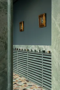 A dimly lit hallway with stone walls, two framed pictures, and a cabinet, creating a cozy atmosphere