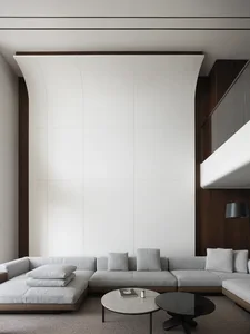 Empty modern living room with a couch, chairs, and pillows, well-lit by natural sunlight through windows