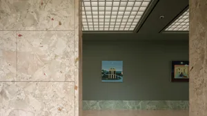 A calm and inviting gallery interior featuring a painting of a building with a clock tower and water feature, set against a neutral background