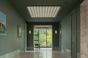 A bright and inviting hallway with a large window, two chairs, and natural light