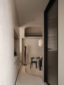 A cozy dining space with a black table surrounded by two chairs, creating a warm and inviting atmosphere