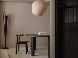 Cozy dining space with a wooden table, two chairs, and books, creating a warm and inviting atmosphere