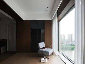 窗前木椅的溫馨客廳空間，周圍環繞書籍與自然光線
