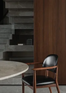A warm and inviting dining space with a wooden chair, dining table, and scattered books, situated near a doorway