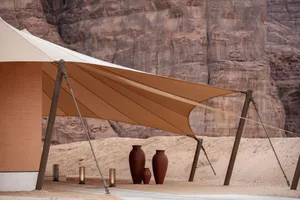 A shaded outdoor area with a tent-like structure, three large vases, and a relaxing atmosphere