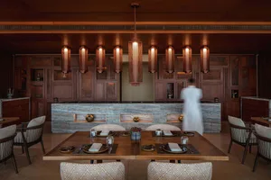 Warm and inviting kitchen space with wooden elements, stone countertops, a dining table, and decorative items