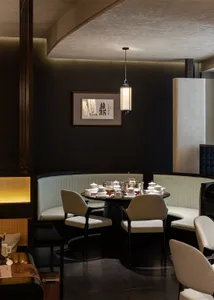 A dining area with a round table, multiple chairs, and a sophisticated ambiance, featuring tasteful decorations and well-arranged furniture