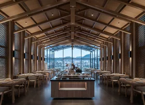 Warm and inviting restaurant interior with wooden floors and walls, featuring dining tables and chairs, and a cozy atmosphere