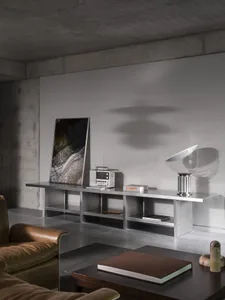 Modern living room with a couch, chair, and dining table, featuring grey walls and a concrete floor, with various pieces of furniture and decorative items
