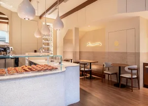 Inviting kitchen space with a dining area, featuring a counter with displayed items, chairs, and a warm atmosphere