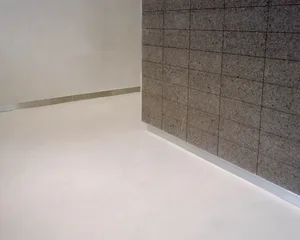 A clean and well-lit hallway with a white tile floor, a mirror on one wall, and a doorway leading to another room