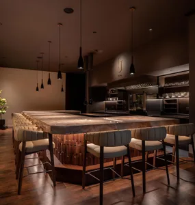 Modern restaurant kitchen with a marble island, stools, chairs, and a sophisticated atmosphere