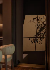 A white chair sits in front of a window with curtains, creating a cozy and inviting atmosphere