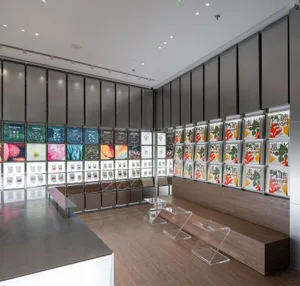 極簡設計的現代展示空間，陳列書籍、瓶器與花瓶，自然光與人工燈光營造明亮氛圍