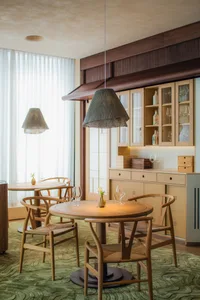 A warm and inviting dining space with a wooden table, chairs, and wine glasses, creating a cozy atmosphere for socializing and dining