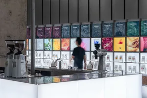 A bustling coffee shop with modern displays, TV screens, and comfortable atmosphere, featuring a counter and various equipment