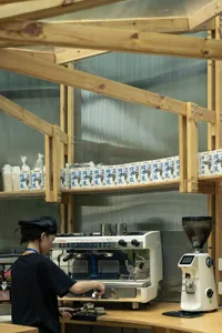 Industrial kitchen with commercial appliances, bottles, and a person, suggesting a professional food preparation environment