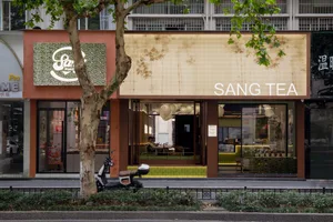 A modern Asian restaurant with orange walls, natural light, and comfortable seating for customers