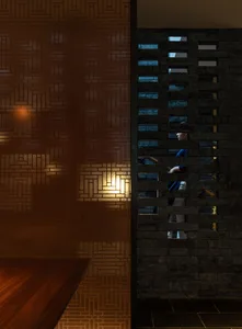 Dimly lit room with a brick wall, a wooden table, and two people standing on either side