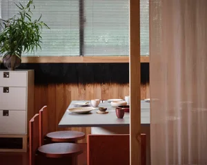 a dining table set with bowls, cups, and spoons in a cozy asian restaurant interior