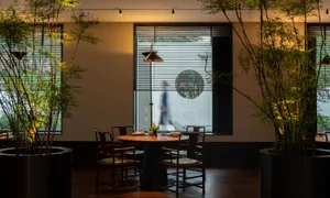 A round dining table surrounded by chairs in a warm and inviting atmosphere, set up for dinner in a restaurant or private home