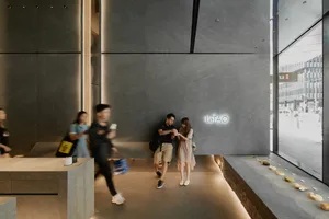 A bustling public space with people walking and navigating through the area, some carrying handbags and a backpack