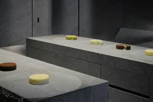 A kitchen scene with two countertops featuring cakes, cheese, and sandwiches, creating an inviting atmosphere for guests