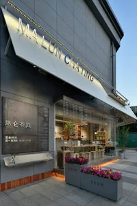 A modern Asian restaurant with natural light, tables, chairs, and potted plants creating a comfortable dining atmosphere