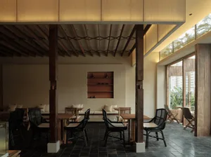 Open modern dining area with wooden elements, multiple tables, and comfortable seating for socializing and meals